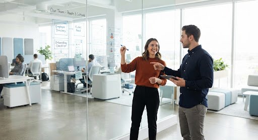 Designers sketching on a glass whiteboard
